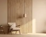 Drewniana ściana z pionowych lameli, fotel, stolik z rośliną i wazon. Inspiracja, jak samemu zrobić lamele.