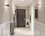 Nowoczesny przedpokój z praktycznymi ścianami ozdobionymi sztukaterią. Dyskretne oświetlenie i lustro dodają elegancji.