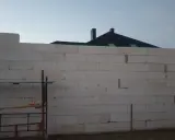Budowa domu z bloczków, zielona linia laserowa wyznacza poziom. To dobry pomysł na krzywe ściany, jeśli chcesz uzyskać ciekawy efekt architektoniczny.