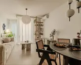 Salon w stylu japandi z beżową sofą, kamiennym stolikiem i drewnianymi meblami.