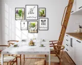 Aranżacja pustej ściany w kuchni z ramkami: "This kitchen full of love", kieliszek, zioła i sztućce.