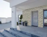Kamien na klatce schodowej w domu, ozdobiony kamienną okładziną, tworzy eleganckie wejście.
