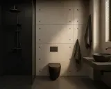 Nowoczesna łazienka z prysznicem i czarną ścianą w tle. Betonowe panele, czarna toaleta i umywalka tworzą minimalistyczny design.