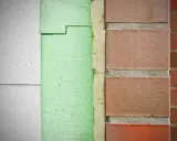 Warstwowa izolacja budynku: biały styrodur, zielona pianka, cegła. Dowiedz się, czym malować styrodur, by zabezpieczyć go przed warunkami atmosferycznymi.