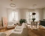 Przytulny salon w beżu z wygodnymi sofami, okrągłym stołem i sztuką na ścianie.