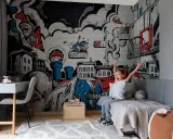 Chłopiec cieszy się w pokoju z dynamicznym **graffiti w pokoju** na ścianie, przedstawiającym miasto i elementy koszykówki.