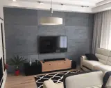 Nowoczesna ściana za telewizorem z betonowej płyty, idealna inspiracja co na sciane za telewizor.