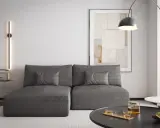 Nowoczesny salon z szarą kanapą i obrazem na ścianie. Ciepły szary kolor ścian tworzy przytulną atmosferę.