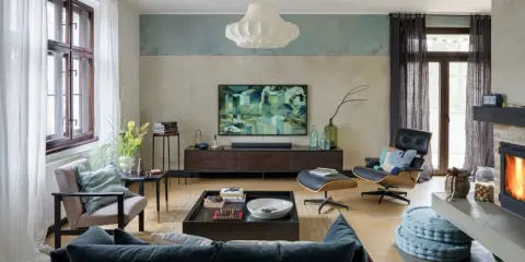 Nowoczesny salon z wygodną kanapą i fotelem. Abstrakcyjny obraz na ścianie dodaje charakteru.