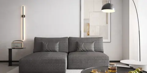 Nowoczesny salon z szarą kanapą i obrazem na ścianie. Ciepły szary kolor ścian tworzy przytulną atmosferę.