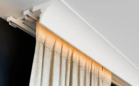 Nowoczesna blenda przy suficie ukrywa szynę zasłonową, tworząc elegancką linię.