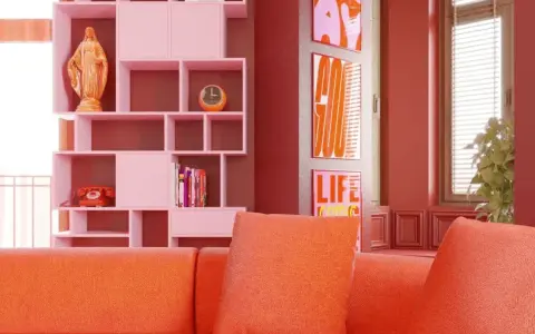 Pomarańczowa kanapa i różowe regały tworzą radosny, **dopamine decor**. Na półce figurka, telefon i zegar. Obok plakaty z napisami.