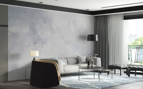 Nowoczesny salon z sofą, stolikami i fotelem. Ściana ozdobiona tapetą szary beton nadaje wnętrzu industrialny charakter.