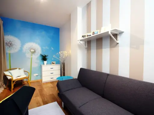 Jasne, oto propozycja:

Salon z fototapetą z dmuchawcami i asymetryczne pasy na ścianie tworzą przytulną atmosferę.