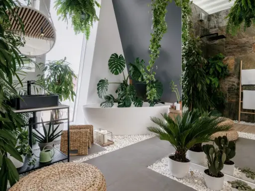 Łazienka w stylu biophilic design, pełna zieleni, z wanną, prysznicem i umywalką.