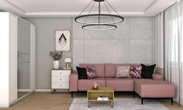 Różowa kanapa i kolorowe poduszki ocieplają szary salon. Wazon z kwiatami i stylowa lampka dodają przytulności.