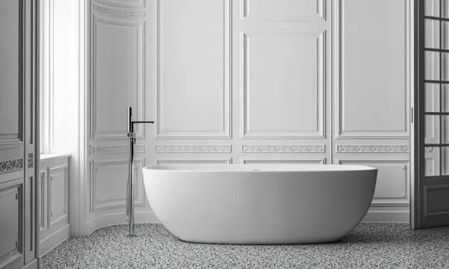 Elegancka łazienka ze sztukaterią, wolnostojącą wanną i nowoczesną armaturą.