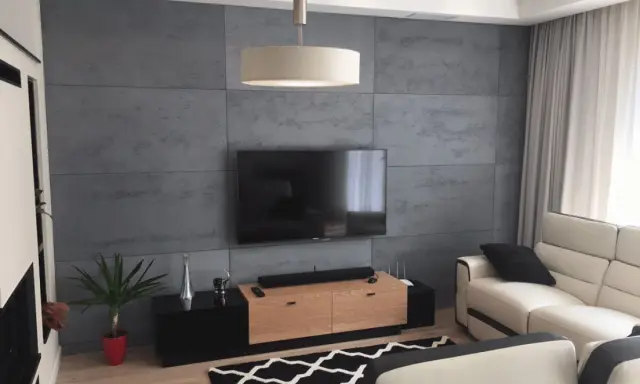 Nowoczesna ściana za telewizorem z betonowej płyty, idealna inspiracja co na sciane za telewizor.
