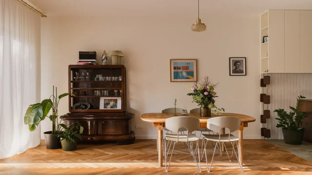 Jadalnia inspiracje: drewniany stół, krzesła, antyczna komoda, rośliny i sztuka tworzą przytulną atmosferę.