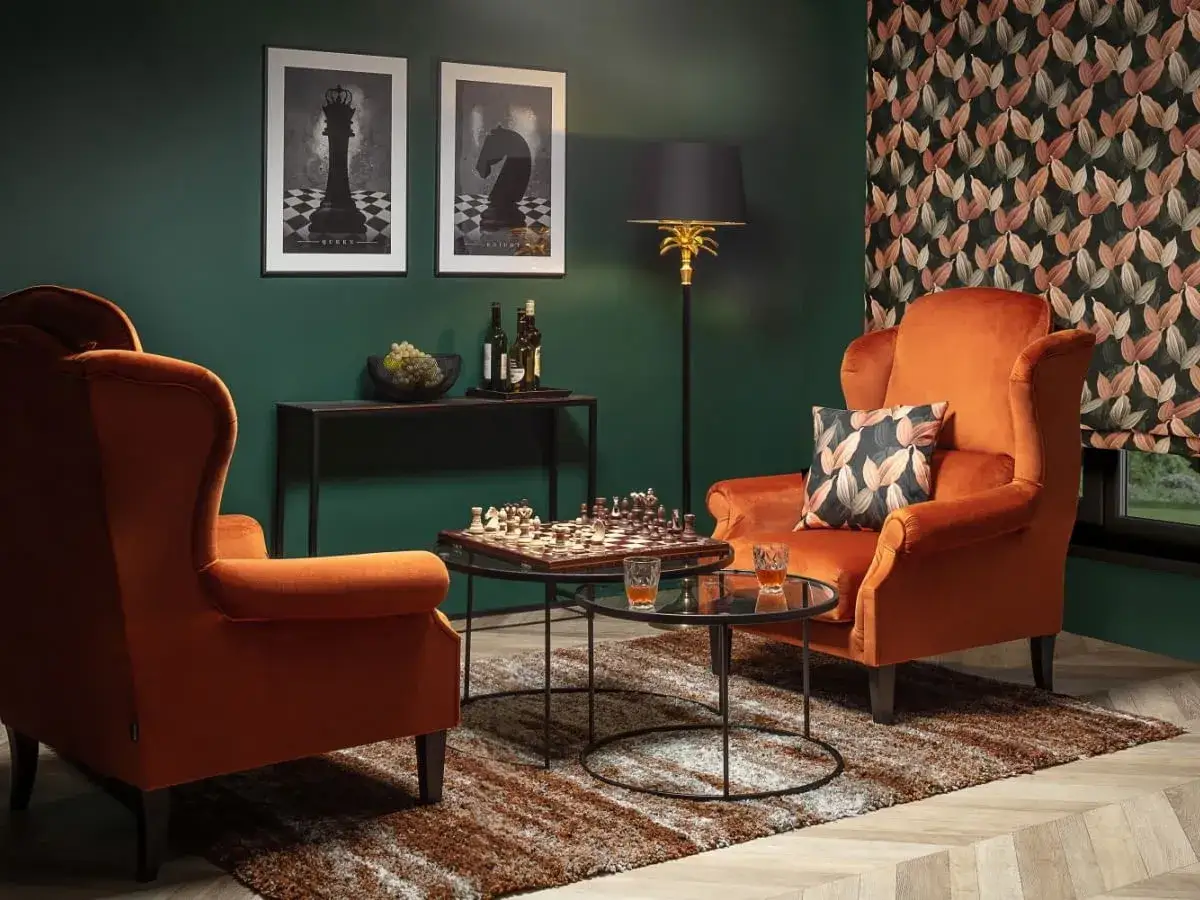 Pomarańczowe fotele i szachownica tworzą przytulny kącik. Ten dopamine decor zachęca do relaksu i intelektualnych rozgrywek.