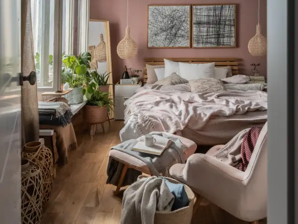 Sypialnia inspiracje: przytulne łóżko z narzutą, wiklinowe lampy, dużo zieleni i naturalne materiały tworzą relaksującą atmosferę.